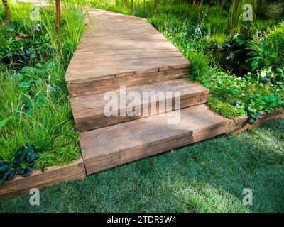 Sentiero nel giardino a forma di ponte di legno Foto Stock