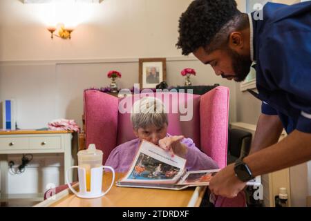 Infermiera Evans Sorbeng (dal Ghana) con la residente Angela Morgan (76) nella sala diurna della St Cecilias Nursing Home Scarborough St Cecilias Nursing Home Scarborough. Foto Stock