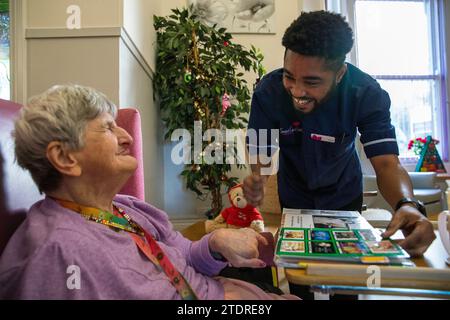 Infermiera Evans Sorbeng (dal Ghana) con la residente Angela Morgan (76) nella sala diurna della St Cecilias Nursing Home Scarborough St Cecilias Nursing Home Scarborough. Foto Stock