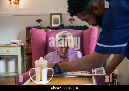 Infermiera Evans Sorbeng (dal Ghana) con la residente Angela Morgan (76) nella sala diurna della St Cecilias Nursing Home Scarborough St Cecilias Nursing Home Scarborough. Foto Stock