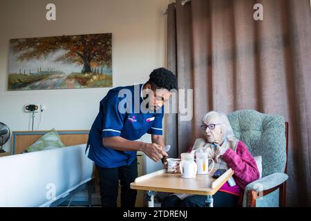 Infermiera ghanese Evans Sarbeng con residente Phyllis Padham (97) presso la St Cecilias Nursing Home Scarborough. St Cecilias Nursing Home Scarborough. Foto Stock