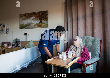 Infermiera ghanese Evans Sarbeng con residente Phyllis Padham (97) presso la St Cecilias Nursing Home Scarborough. St Cecilias Nursing Home Scarborough. Foto Stock