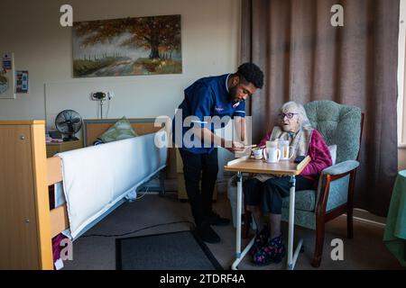 Infermiera ghanese Evans Sarbeng con residente Phyllis Padham (97) presso la St Cecilias Nursing Home Scarborough. St Cecilias Nursing Home Scarborough. Foto Stock