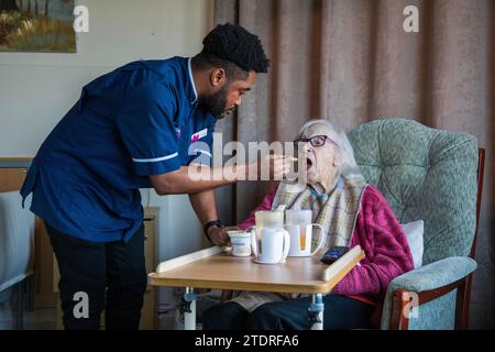 Infermiera ghanese Evans Sarbeng con residente Phyllis Padham (97) presso la St Cecilias Nursing Home Scarborough. St Cecilias Nursing Home Scarborough. Foto Stock