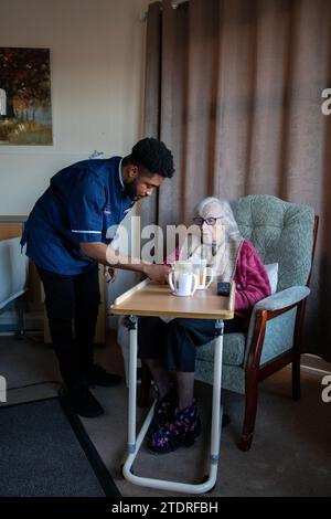 Infermiera ghanese Evans Sarbeng con residente Phyllis Padham (97) presso la St Cecilias Nursing Home Scarborough. St Cecilias Nursing Home Scarborough. Foto Stock