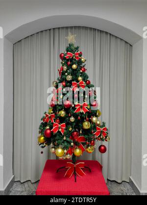 Eleganza festiva. Albero di Natale nella cornice ad arco della hall. Foto Stock