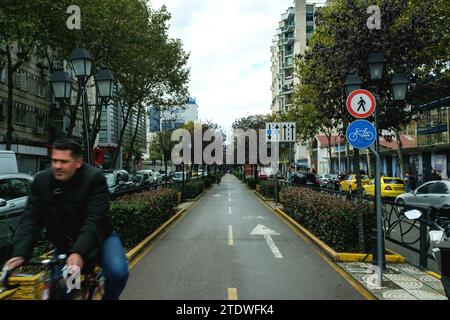 Tirana, Albania - 29 novembre 2023: Una foto che ritrae un uomo in bicicletta su una pista ciclabile designata a Tirana. Foto Stock