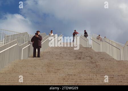 Tirana, Albania - 29 novembre 2023: Una foto diurna che mostra le persone in piedi sulle scale dell'iconico edificio della Piramide a Tirana. Foto Stock