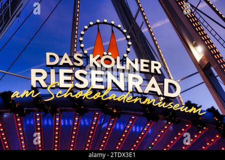 Colonia, Germania 18 dicembre 2023: Pubblicità al neon per la ruota panoramica di colonia al museo del cioccolato durante il mercatino di natale del porto 2023 in Foto Stock