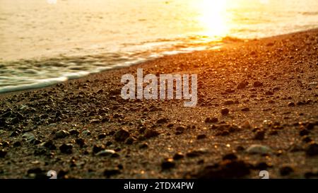 Le onde che si infrangono sulla spiaggia all'alba possono essere viste da vicino Foto Stock