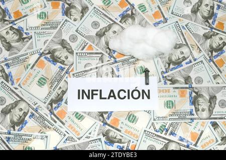 Parola spagnola "Inflación" scritta su Un Libro e una freccia che indica Una nuvola che significa inflazione alle stelle a seguito della crisi economica Foto Stock