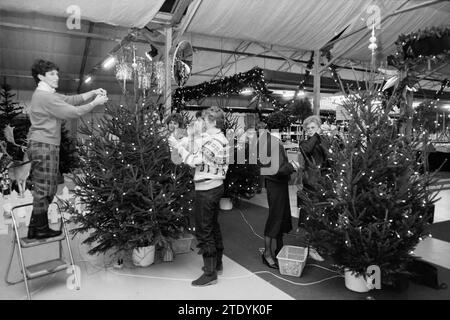 Decorare un albero di Natale dalle donne sindaco della regione e ritrarre Mr. Kooy dal centro giardino, alberi di Natale e Natale, giardini e parchi, 09-12-1985, Whizgle News from the Past, su misura per il futuro. Esplora le narrazioni storiche, l'immagine dell'agenzia olandese olandese con una prospettiva moderna, colmando il divario tra gli eventi di ieri e quelli di domani. Un viaggio senza tempo che delinea le storie che plasmano il nostro futuro. Foto Stock