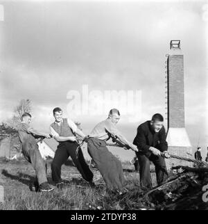 Ragazzi che scavano ceppi di alberi. Sullo sfondo un camino CA. Ottobre 1945 Foto Stock