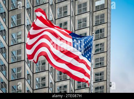Bandiera americana davanti al grattacielo. Foto Stock