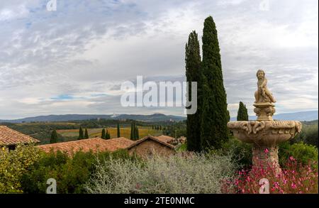 Montalcino, Italia - 16 novembre 2023: Vista delle pensioni e dei giardini di Villa Banfi con il paesaggio toscano alle spalle Foto Stock