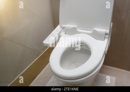 Toilette high-tech con bidet automatico installata nei servizi igienici pubblici. Foto Stock