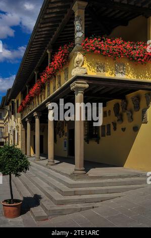 Il Palazzo Pretorio o Municipio di Fiesole, una cittadina collinare sopra Firenze, Toscana, Italia, la sua loggia decorata con fiori rossi luminosi. Il Palazzo si affaccia su Piazza min da Fiesole, la piazza principale della città. Foto Stock