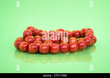 Vecchie perle di legno rosse su sfondo verde chiaro con riflesso Foto Stock