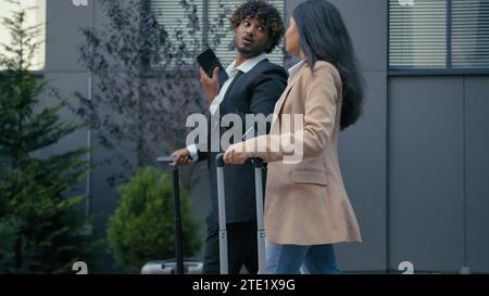 Vista laterale, uomo d'affari indiano leader donna d'affari araba imprenditrice esecutiva due persone multirazziali, partner commerciali, colleghi, camminano Foto Stock
