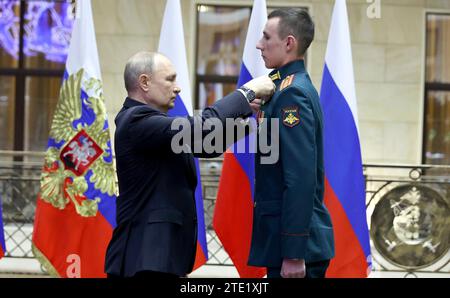 Mosca, Russia. 19 dicembre 2023. Il presidente russo Vladimir Putin, a sinistra, presenta la medaglia d'oro al maggiore Andrei Mityashin durante una cerimonia presso il Centro nazionale di controllo della difesa, il 19 dicembre 2023 a Mosca, in Russia. Crediti: Mikhail Klimentyev/Cremlino Pool/Alamy Live News Foto Stock