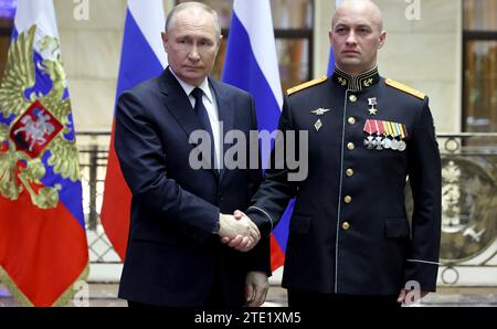 Mosca, Russia. 19 dicembre 2023. Il presidente russo Vladimir Putin, a sinistra, stringe la mano al tenente colonnello Sergei Irkhin dopo aver presentato la medaglia d'oro al Centro nazionale di controllo della difesa, il 19 dicembre 2023 a Mosca, in Russia. Crediti: Mikhail Klimentyev/Cremlino Pool/Alamy Live News Foto Stock