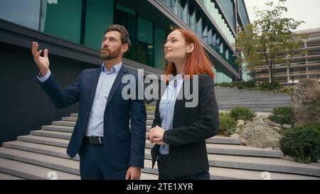 Due partner d'affari caucasici, uomini d'affari che si incontrano in città vicino all'edificio degli uffici, stringono la mano ai soci imprenditori uomini d'affari adulti donna d'affari Foto Stock