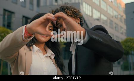 Coppia indiana uomo d'affari arabo uomo d'affari donna d'affari colleghi colleghi colleghi partner che mostrano la forma del cuore con le dita delle mani a Foto Stock