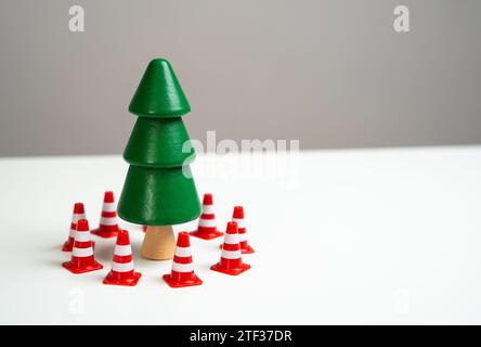 Un pino è circondato da coni stradali. Preserva le foreste dalla deforestazione durante Natale e Capodanno. Passare agli alberi artificiali. Preservi Foto Stock