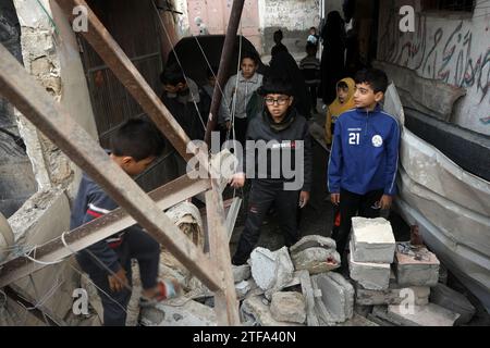 Rafah, Gaza. 19 dicembre 2023. I ragazzi palestinesi guardano una casa e un veicolo distrutti dopo gli attacchi aerei israeliani sulle case residenziali, nel campo profughi di al-Shaboura, a Rafah, nella Striscia di Gaza meridionale, mercoledì 20 dicembre, 2023. tra le continue battaglie tra Israele e i combattenti palestinesi, i paesi membri del Consiglio di sicurezza delle Nazioni Unite stanno intensamente negoziando sui progetti di risoluzione sulla guerra Israele-Gaza, causando anche il rinvio della votazione almeno a mercoledì mattina. Foto di Ismael Mohamad/UPI credito: UPI/Alamy Live News Foto Stock