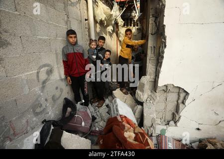 Rafah, Gaza. 19 dicembre 2023. I ragazzi palestinesi guardano una casa e un veicolo distrutti dopo gli attacchi aerei israeliani sulle case residenziali, nel campo profughi di al-Shaboura, a Rafah, nella Striscia di Gaza meridionale, mercoledì 20 dicembre, 2023. tra le continue battaglie tra Israele e i combattenti palestinesi, i paesi membri del Consiglio di sicurezza delle Nazioni Unite stanno intensamente negoziando sui progetti di risoluzione sulla guerra Israele-Gaza, causando anche il rinvio della votazione almeno a mercoledì mattina. Foto di Ismael Mohamad/UPI credito: UPI/Alamy Live News Foto Stock