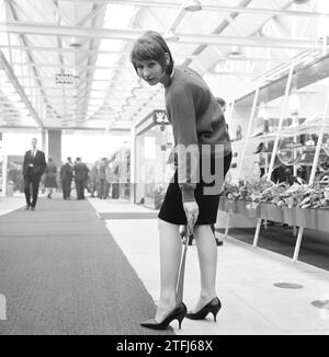 Fiera internazionale delle calzature a Jaarbeurs a Utrecht, donna che utilizza un corno per scarpe CA. 13 aprile 1964 Foto Stock