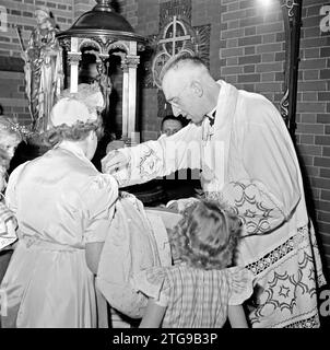 Il chierico batte un bambino ca. Maggio 1950 Foto Stock