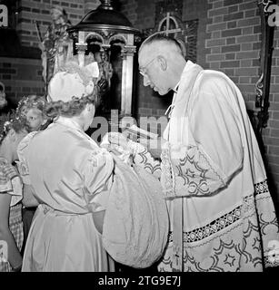 Il chierico batte un bambino ca. Maggio 1950 Foto Stock