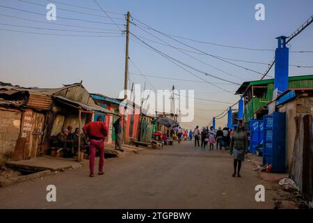 I pedoni camminano lungo le strade trafficate di Kibera Slum, Nairobi. Una visione attraverso la vita quotidiana a Kibera attualmente la più grande baraccopoli dell'Africa e il giorno Foto Stock