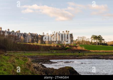 Crawfordsburn, County Down, Irlanda del Nord 13 dicembre 2023 - lungomare di Crawfordsburn con grande casa di campagna sullo sfondo Foto Stock