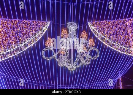 Dettaglio di un lampadario appeso a un soffitto blu fatto di luci natalizie come decorazione nel Municipio di Siviglia, intorno alla Cattedrale, a natale tim Foto Stock