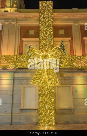 Decorazioni con luci natalizie a forma di arco regalo nel municipio di Huelva, Andalusia, decorazioni con luci natalizie a forma di arco regalo a Hu Foto Stock