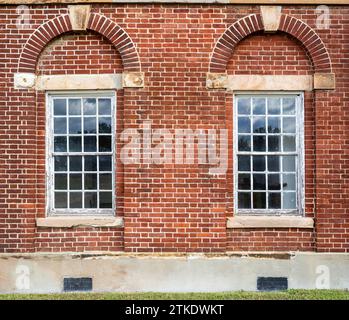 Un'intricata facciata in mattoni rossi a Fort Washington in Virginia vanta una disposizione simmetrica di accattivanti finestre che evocano un'incantevole architettura Foto Stock