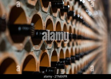 Archivio di vino rosso con tappi neri nella cantina in speciali aperture in mattoni. Bela Krajina, Slovenia Foto Stock