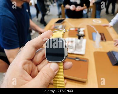 Parigi, Francia - 23 settembre 2022: In un Apple Store, l'acclamato orologio mostra l'ora alle 16:54, con un cliente che fa shopping in sottofondo, in evidenza Foto Stock