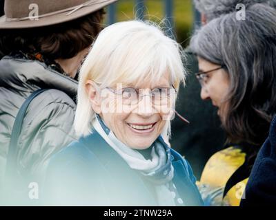 Strasburgo, Francia - 29 marzo 2023: Una donna sorridente che guarda la telecamera in prima fila della Corte per i diritti umani, a una protesta come un gruppo di anziani chiede Foto Stock