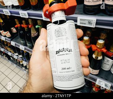 Parigi, Francia - 10 novembre 2023: Un cliente si prepara per le vacanze e le cene di festa, selezionando Angostura Aromatic Bitters con il 44,7% di alcol, un pr Foto Stock