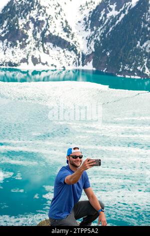 L'escursionista cattura un selfie con lo splendido blu del lago Garibaldi. Foto Stock
