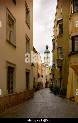 Hall in Tirolo e la chiesa parrocchiale di San Nicola in Austria. Una stradina nel centro storico di Hall in Tirolo, Austria. La torre del santo Foto Stock