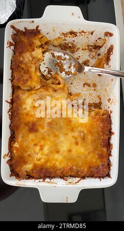 Lasagne cotte a metà in un piatto da forno Foto Stock