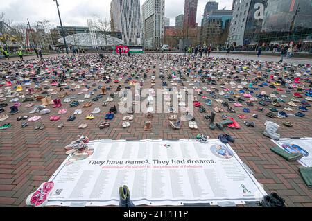 "Hanno nomi. Avevano dei sogni. Grande poster che nomina alcuni dei morti israeliani durante il suo assedio di 10 settimane a Gaza. Più di 8000 paia di scarpe per bambini sono state disposte in file ordinati sulla De Binnenrotte, una piazza a Rotterdam. Le scarpe erano un gesto simbolico dei bambini uccisi in Palestina e uccisi dai bombardamenti indiscriminati da terra, mare e aria da parte delle forze di difesa israeliane (IDF). Dal 7 ottobre, il bilancio delle vittime ha superato i 20.000 e almeno 40.000 feriti, con 7.000 o 8.000 corpi rimasti sepolti sotto le macerie, sono per lo più donne e bambini. Si spera Foto Stock