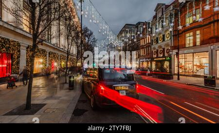 I taxi fanno la fila per le tariffe fuori dal Selfridge's a Londra durante le festività. Foto Stock