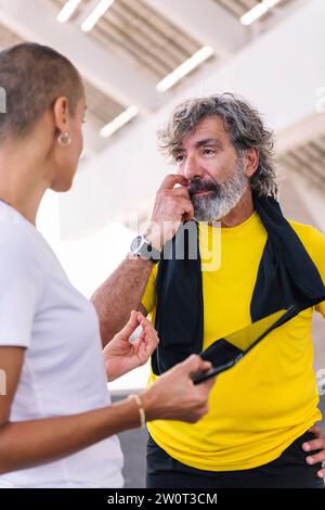 uomo e formatore osservano i progressi dell'allenamento Foto Stock