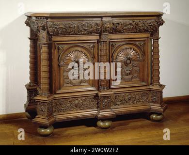 Armadietto con stili ad angolo in forma di colonne toscane semiindipendenti, anonime, c. 1600 - c. 1650 armadio basso in rovere. Gli stili ad angolo e gli stili posteriori delle pareti laterali hanno colonne toscane staccate; lo stile centrale è una mezza colonna. Indossano console con teste di leone. Il cassetto nella parte anteriore è decorato con draghi dal cui corpo salta. Le porte hanno cornissenses, coronate da conchiglie semicircolari. Le cornie hanno una maschera demoniaca al centro. I pannelli del piedistallo mostrano un motivo vaso centrale da cui proviene. Legno dei Paesi Bassi meridionali (materiale vegetale). Cabina bassa in quercia (legno) Foto Stock