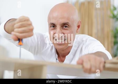 uomo soddisfatto che stringe le viti Foto Stock